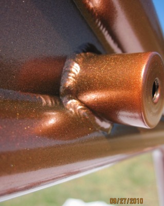 Close up of custom motorcycle frame in Tangelo Mist over Ink Black